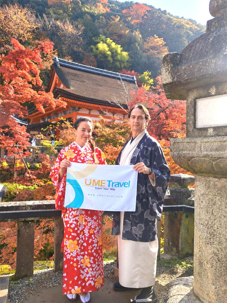 Couple in traditional kimono admiring Kyoto autumn foliage on private UME Travel tour