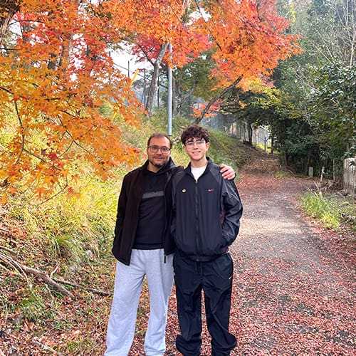 Families with Teens - Father and teenager walking along a scenic autumn foliage trail with vibrant Japanese maples