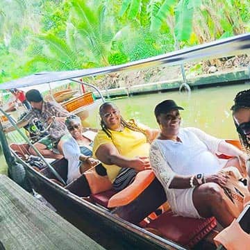 Travelers enjoying a traditional boat ride on Bangkok waterways, Thailand travel experience